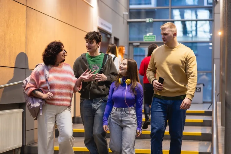 Zaczynasz studia? Ważne informacje dla studentek i studentów 1 roku | Aktualności | Uniwersytet Dolnośląski DSW we Wrocławiu: grupa czterech studentów schodząca po schodach