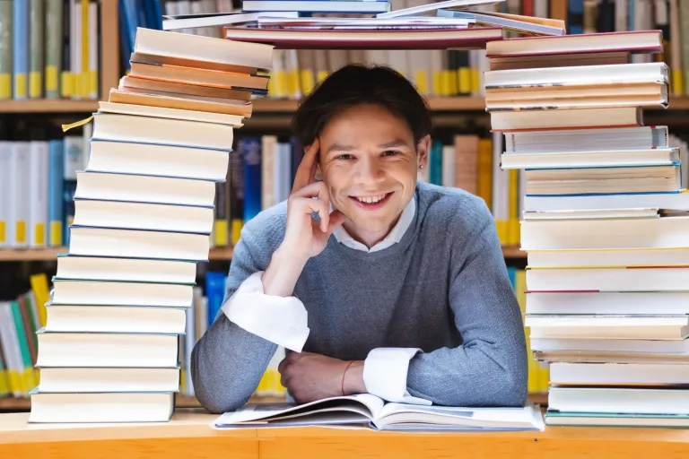 Ciekawe kierunki studiów pedagogicznych i zawody związane z pracą z dziećmi | Uniwersytet Dolnośląski DSW we Wrocławiu: Mężczyzna między książkami
