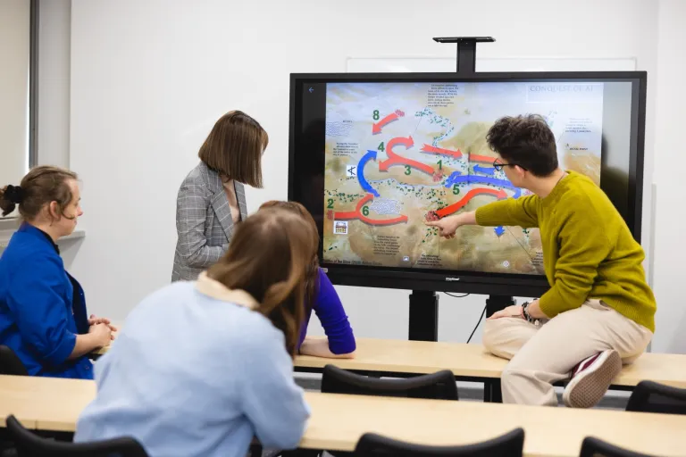 Studia po „mat-inf”? Matematyczno-informatyczne kierunki studiów | Uniwersytet Dolnośląski DSW we Wrocławiu: Grupa osób spoglądająca na telewizor