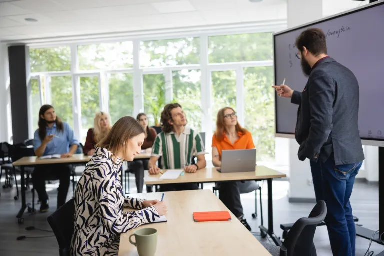 Uniwersytet czy politechnika? Jakie są różnice i co wybrać? | Uniwersytet Dolnośląski DSW we Wrocławiu: Grupa osób w sali wykładowej