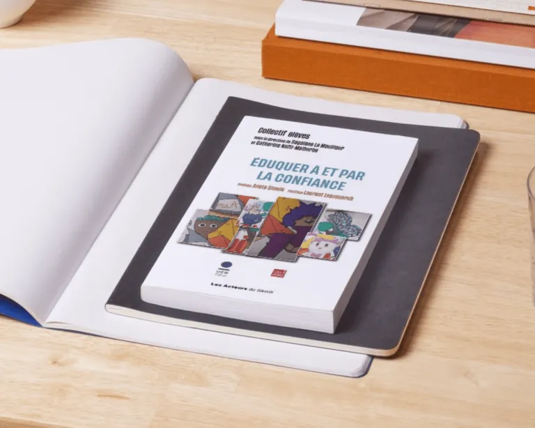 Dr Aneta Słowik autorką rozdziału we francuskojęzycznej monografii | Aktualności | Uniwersytet Dolnośląski DSW we Wrocławiu: książka leżąca na biurku na otwartym zeszycie